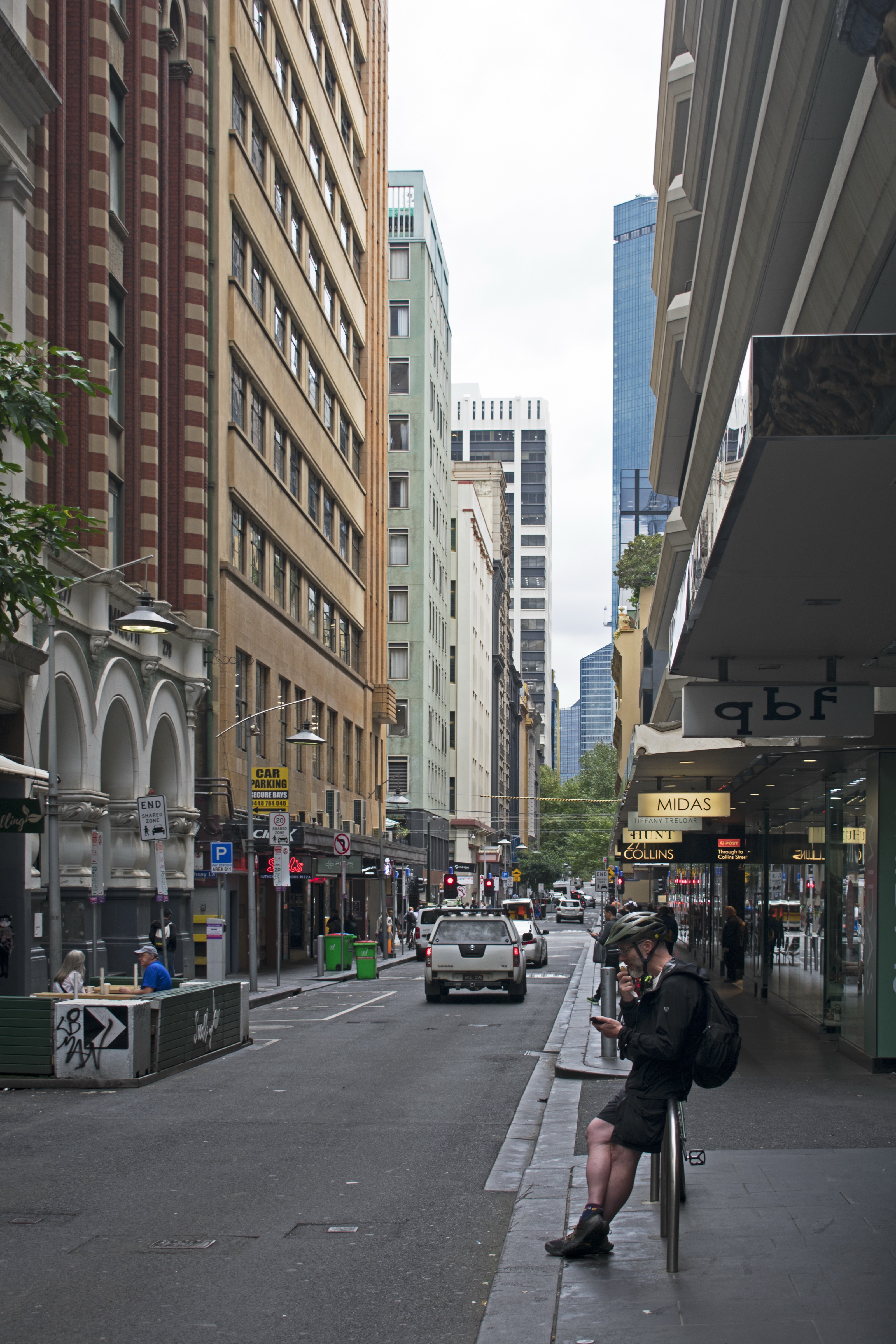 A man on Flinders Lane, Melbourne, looking at his phone